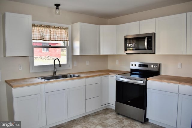 kitchen featuring stainless steel appliances, white cabinetry, and a sink