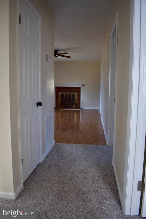 corridor featuring baseboards, visible vents, and carpet flooring