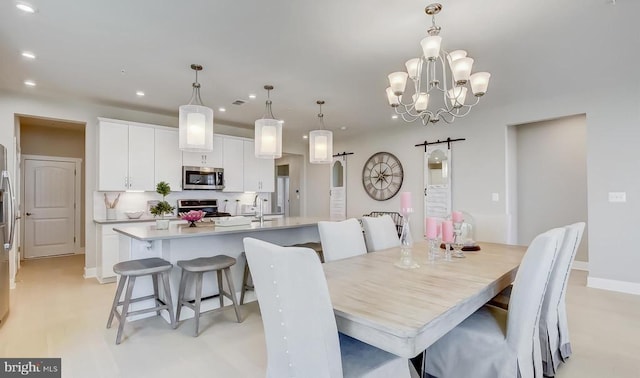 dining space with a barn door and a chandelier