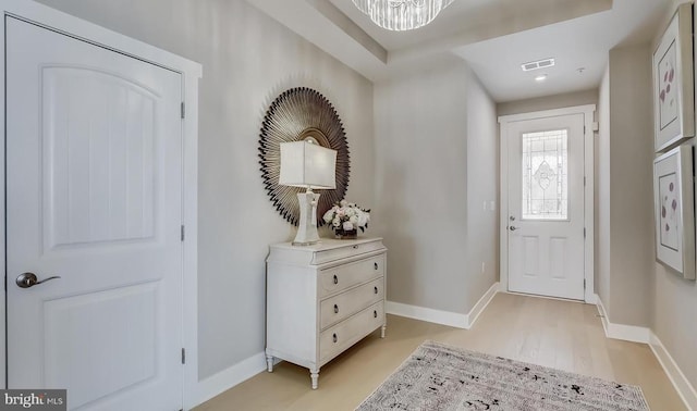 foyer entrance with a chandelier and light hardwood / wood-style floors