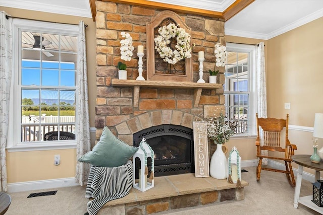 living area featuring ornamental molding, a stone fireplace, carpet flooring, and ceiling fan