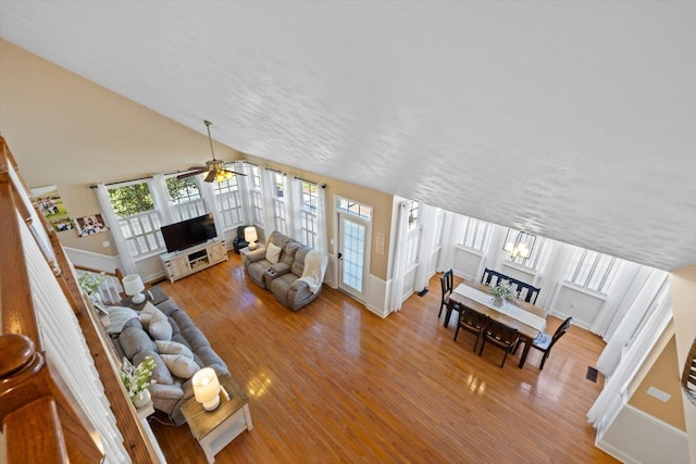 living room with lofted ceiling, hardwood / wood-style flooring, and ceiling fan