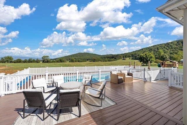 wooden terrace with a fenced in pool and a mountain view