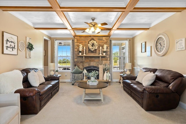 living room with coffered ceiling, a stone fireplace, crown molding, carpet flooring, and ceiling fan