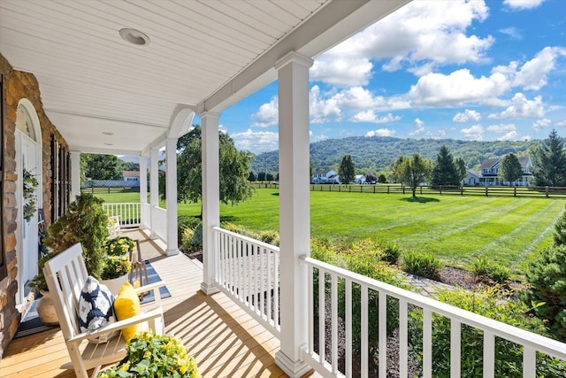 balcony featuring a porch, a mountain view, and a rural view