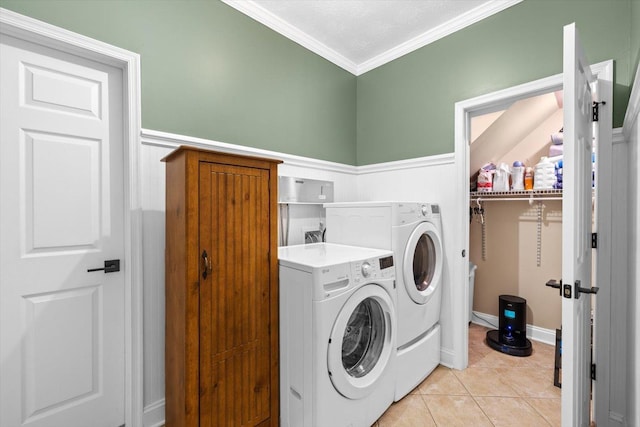 laundry room featuring light tile patterned floors, crown molding, and independent washer and dryer