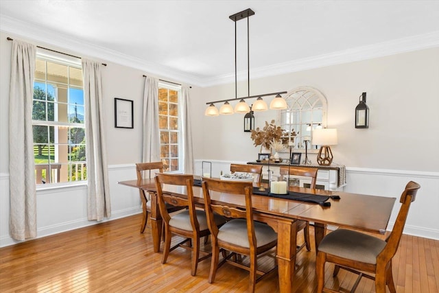 dining space with light hardwood / wood-style flooring and ornamental molding