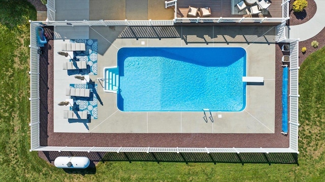 view of swimming pool with a diving board