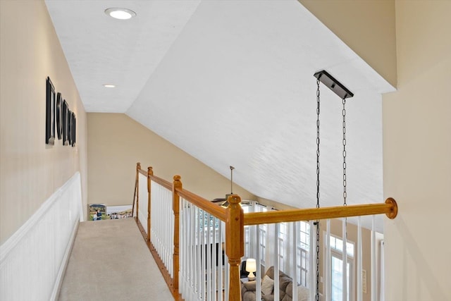 corridor featuring lofted ceiling and light carpet