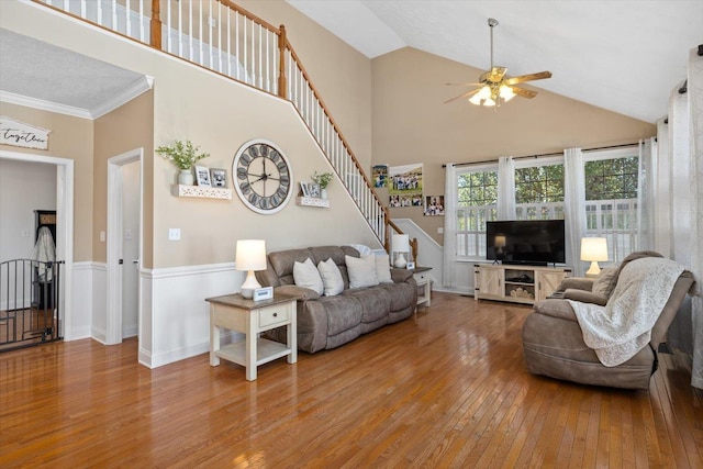 living room with hardwood / wood-style floors, high vaulted ceiling, and ceiling fan