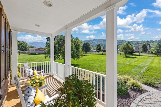 view of patio / terrace featuring a porch, a mountain view, and a rural view