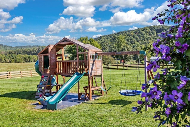 view of jungle gym featuring a rural view and a lawn