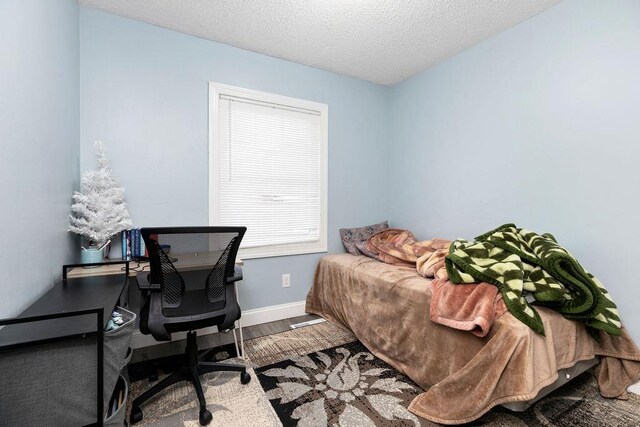 bedroom featuring hardwood / wood-style floors and a textured ceiling