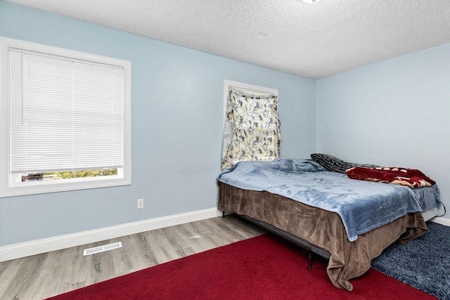 bedroom featuring hardwood / wood-style floors and a textured ceiling