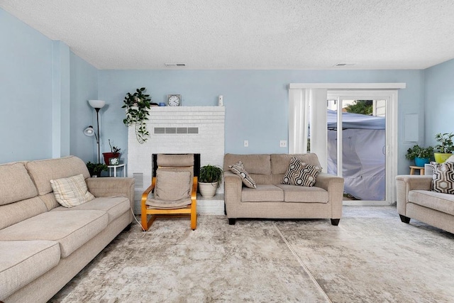 living room featuring a textured ceiling and a fireplace