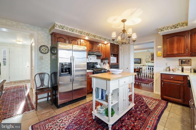 kitchen with stainless steel refrigerator with ice dispenser, decorative light fixtures, an inviting chandelier, and light tile patterned floors