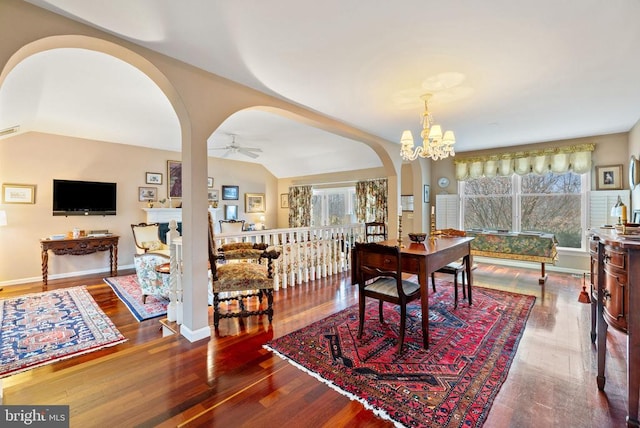 dining room featuring lofted ceiling, hardwood / wood-style flooring, and ceiling fan with notable chandelier