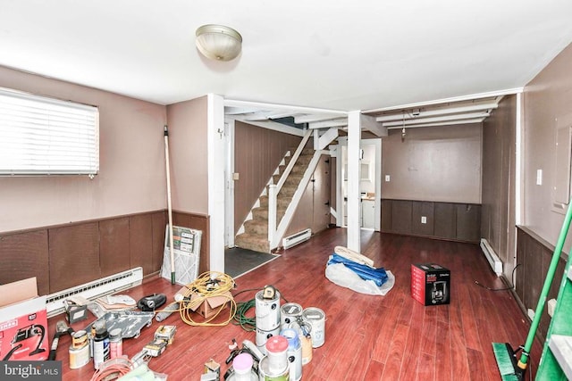 interior space with wainscoting, baseboard heating, wood finished floors, stairway, and a baseboard radiator