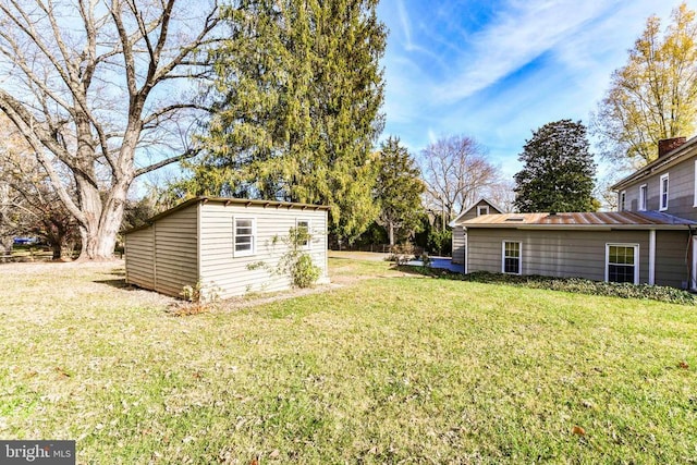 view of yard featuring a storage unit and an outbuilding