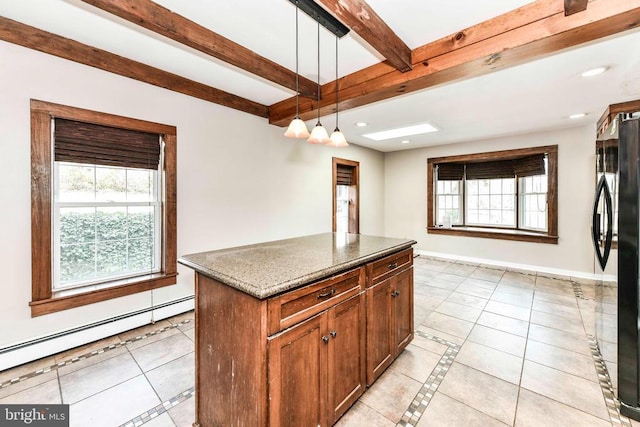 kitchen with baseboard heating, freestanding refrigerator, a wealth of natural light, and light tile patterned floors