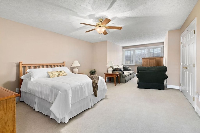 carpeted bedroom featuring ceiling fan and a textured ceiling