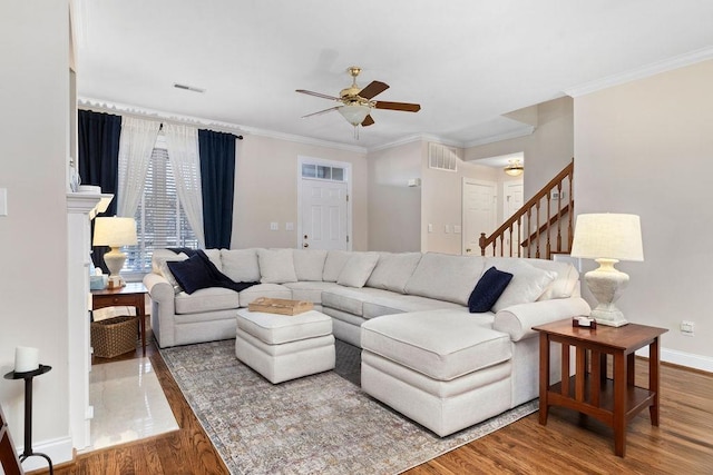 living room with hardwood / wood-style flooring, ornamental molding, and ceiling fan