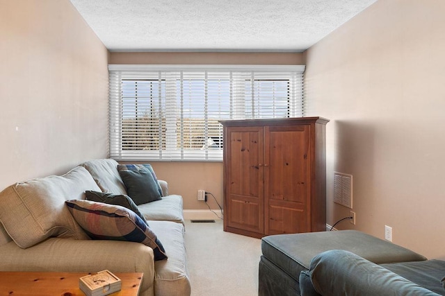 carpeted living room featuring a textured ceiling