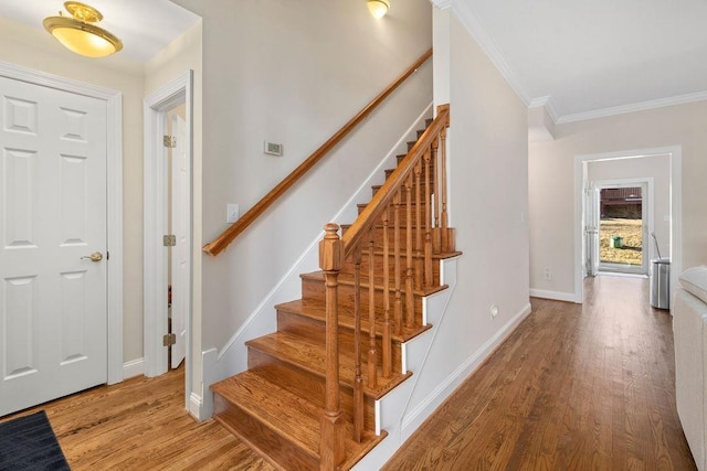 stairway featuring hardwood / wood-style floors and ornamental molding