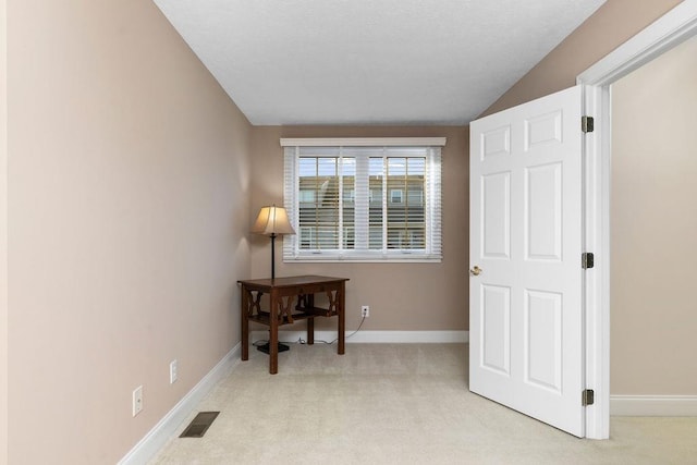 interior space with lofted ceiling and light colored carpet