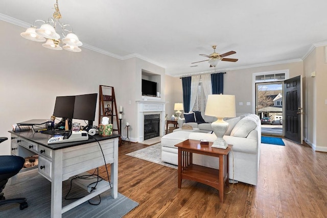 living room featuring wood-type flooring, ceiling fan with notable chandelier, and crown molding