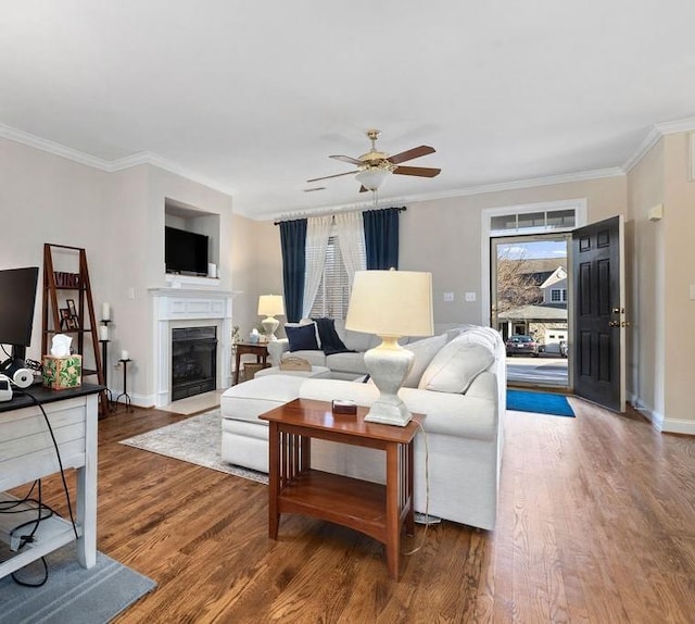 living room with hardwood / wood-style flooring, crown molding, and ceiling fan