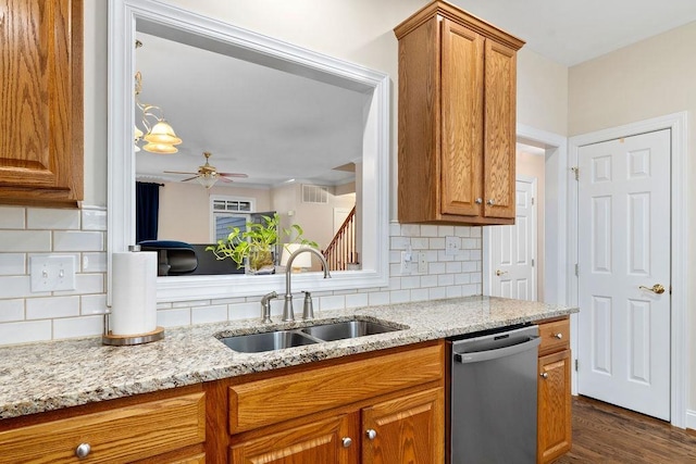 kitchen featuring light stone counters, sink, dark wood-type flooring, and stainless steel dishwasher