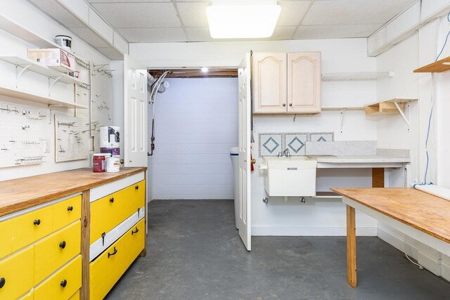 interior space with a paneled ceiling and sink