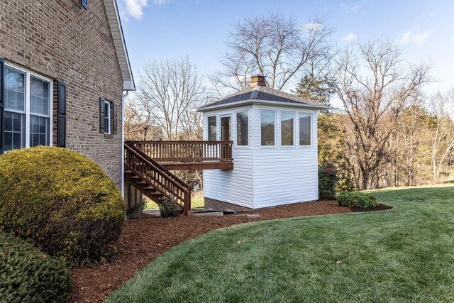 view of side of home featuring a yard and a deck