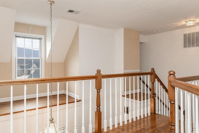 hall featuring hardwood / wood-style flooring and a textured ceiling