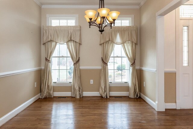 empty room featuring ornamental molding, a wealth of natural light, and hardwood / wood-style floors