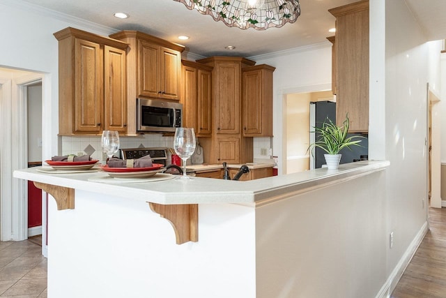 kitchen featuring stainless steel appliances, kitchen peninsula, and a breakfast bar area