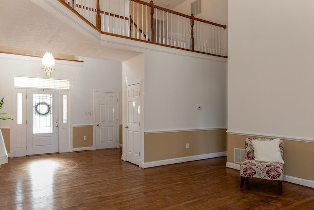 entryway featuring hardwood / wood-style flooring and a towering ceiling