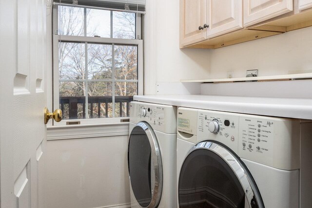 washroom with cabinets and washer and dryer