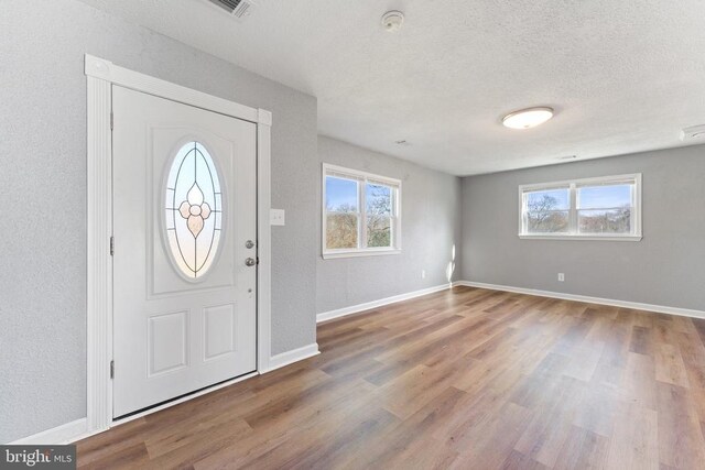 foyer entrance featuring hardwood / wood-style flooring and a textured ceiling