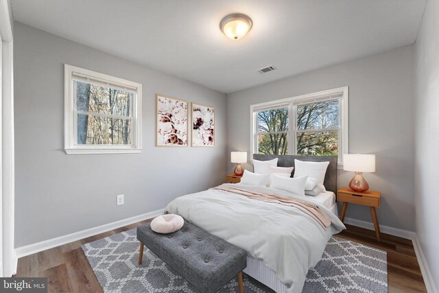 bedroom with dark hardwood / wood-style floors