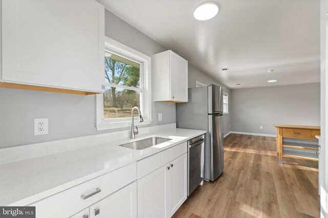 kitchen featuring white cabinetry, stainless steel appliances, light hardwood / wood-style floors, and sink