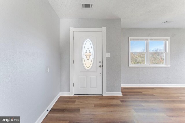 entrance foyer with wood-type flooring and a textured ceiling