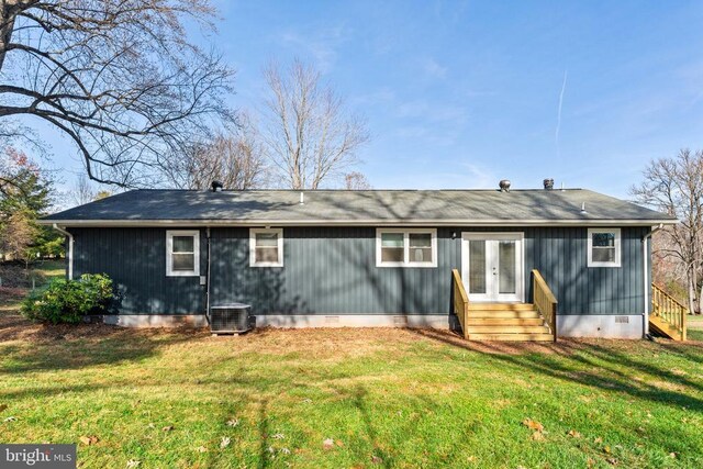 rear view of property with central AC and a lawn