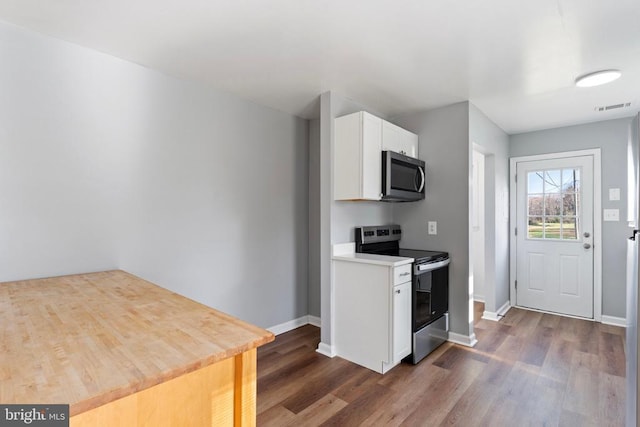 kitchen featuring dark hardwood / wood-style flooring, white cabinetry, and appliances with stainless steel finishes