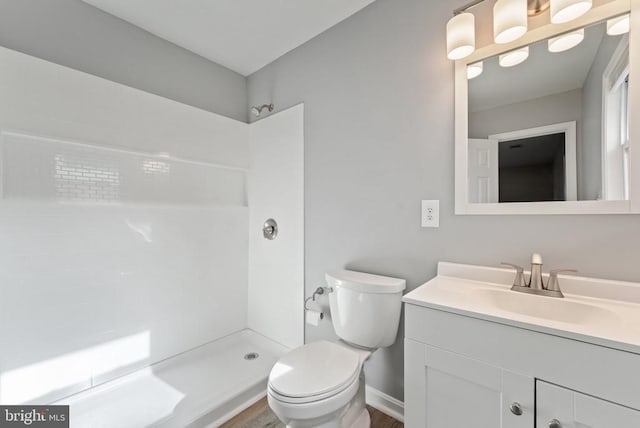 bathroom featuring a shower, vanity, and toilet