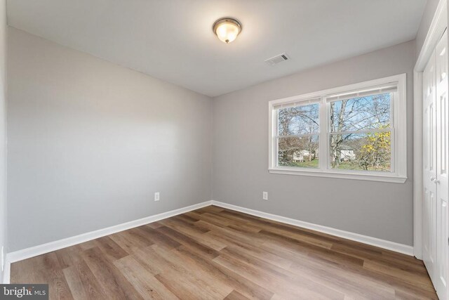 unfurnished bedroom with hardwood / wood-style flooring and a closet