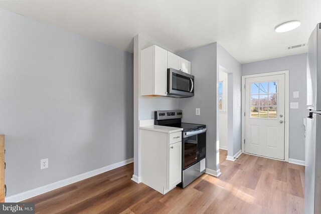 kitchen featuring white cabinetry, stainless steel appliances, and light hardwood / wood-style floors