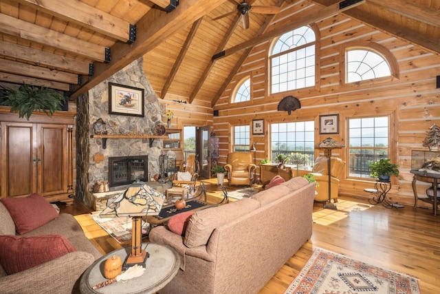 living room featuring wooden walls, a fireplace, wooden ceiling, beam ceiling, and light hardwood / wood-style flooring