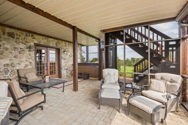 view of patio / terrace with french doors, an outdoor living space, and a hot tub